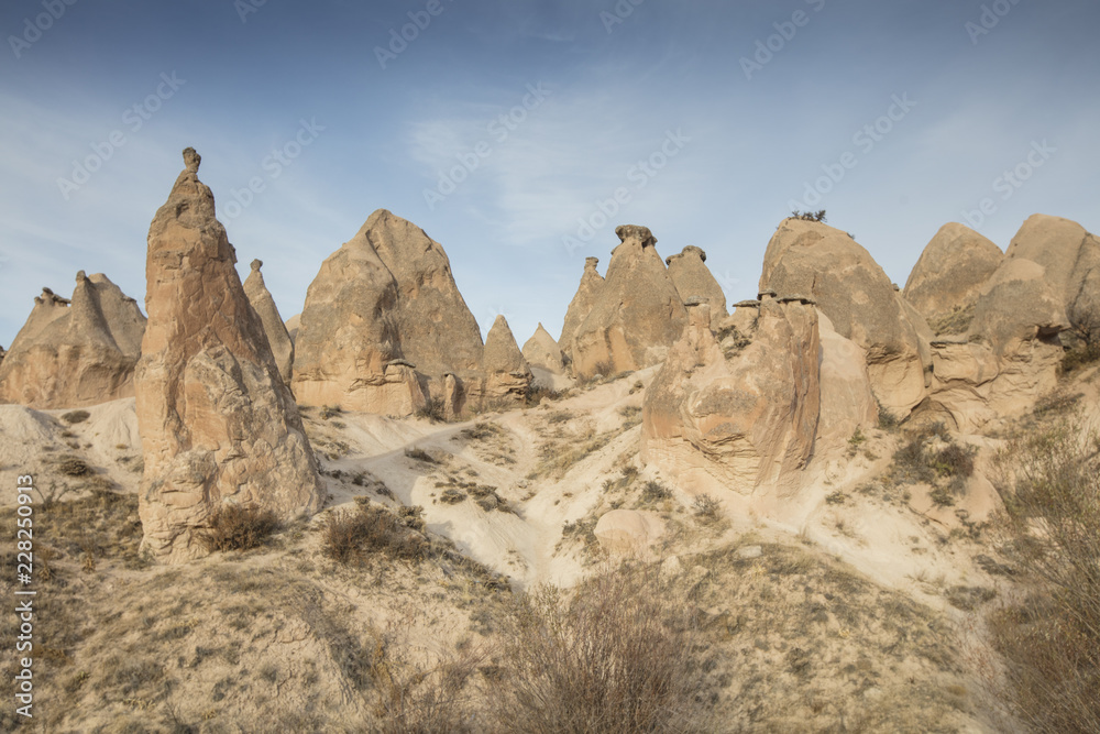 Fototapeta premium Unreal world of Cappadocia. Colorful sunrise in Red Rose valley in April. Cavusin village located, Nevsehir Province in the Cappadocia region of Turkey, Asia. Traveling concept background