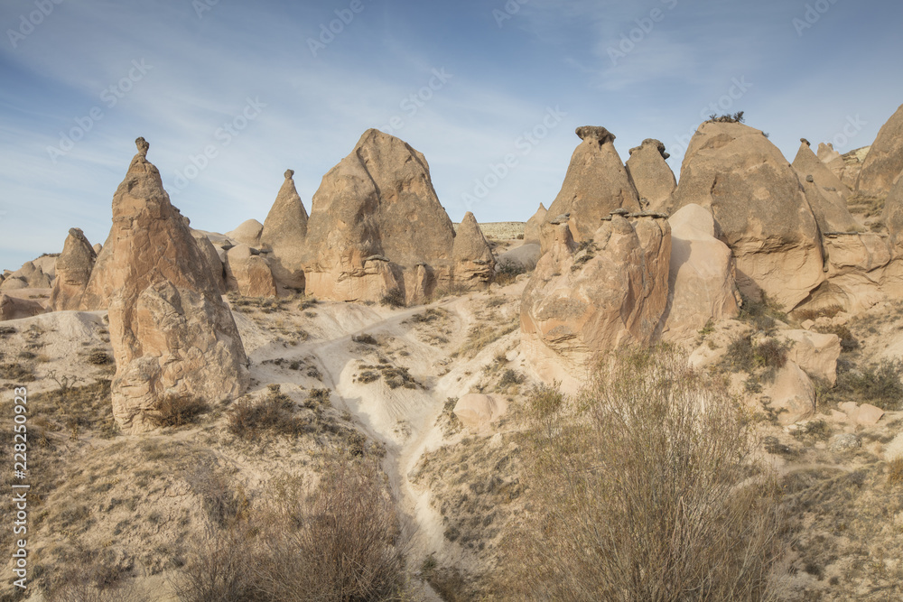 Unreal world of Cappadocia. Colorful sunrise in Red Rose valley in April. Cavusin village located, Nevsehir Province in the Cappadocia region of Turkey, Asia. Traveling concept background