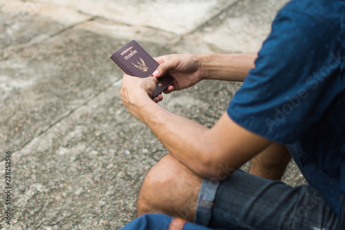 man holding Thai passport on hand waiting for travel. soft focus.