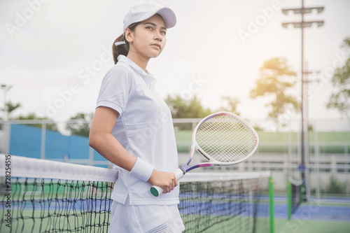 Tennis players playing a match on the court . Young woman playing tennis on court. © Sirichai