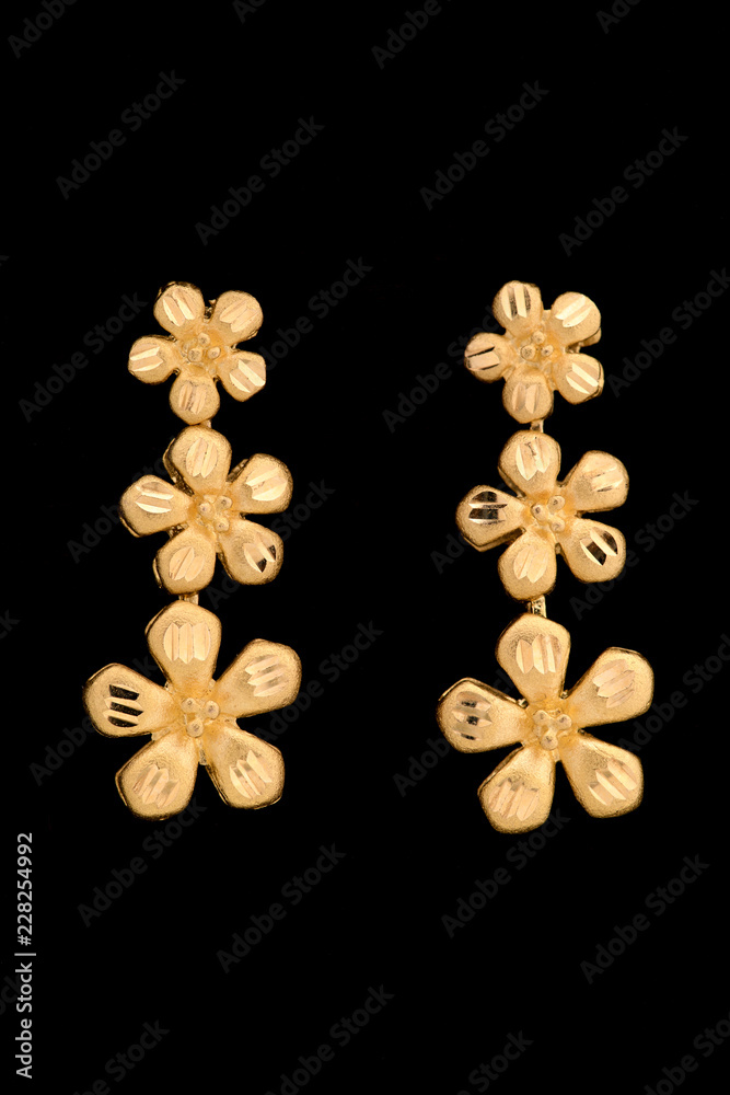 Fototapeta premium Golden earrings on a dark background