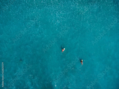 Surfers in tropical ocean waiting wave. Aerial view. © artifirsov