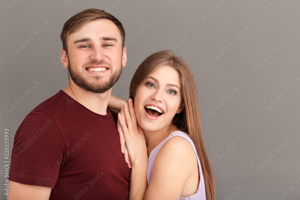 Happy young couple on grey background Happy young couple on grey background