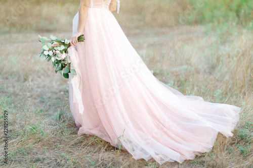 Beautiful bride with bouquet and dress with train