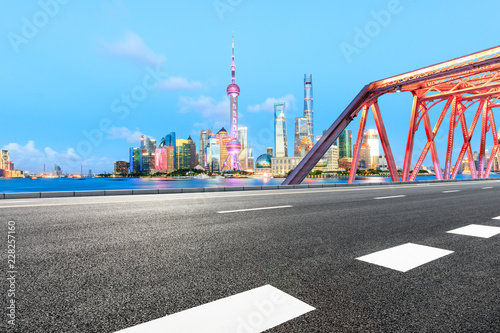 Empty asphalt road and modern city landmark building with steel bridge in shanghai