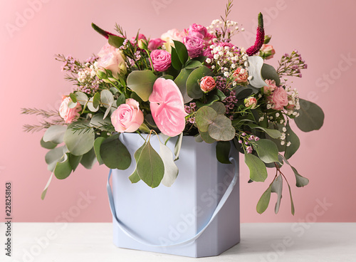 Fototapeta Naklejka Na Ścianę i Meble -  Gift box with beautiful flowers on table against color background
