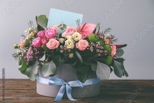Fototapeta Naklejka Na Ścianę i Meble -  Gift box with beautiful flowers and card on wooden table