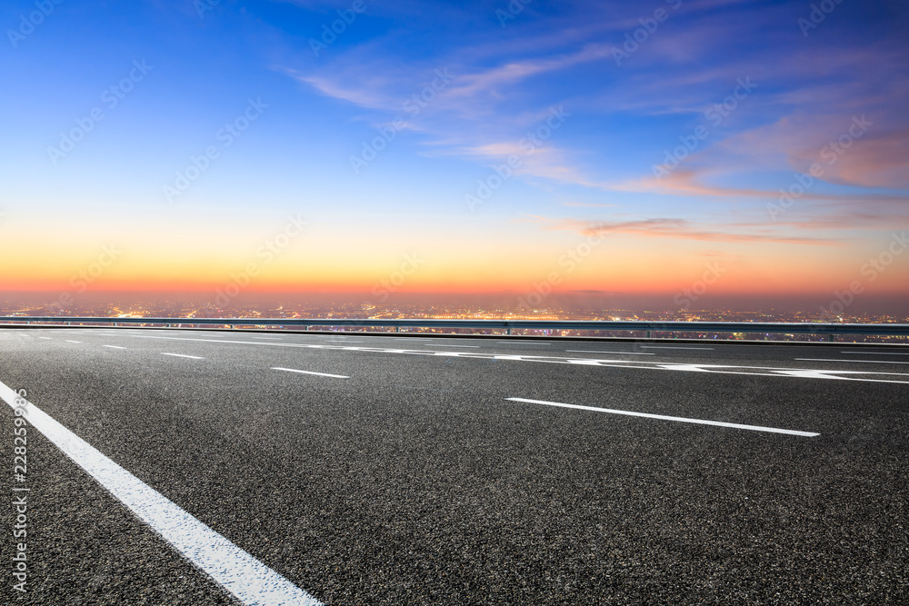 Fototapeta premium Modern city skyline and buildings with empty asphalt road at sunset