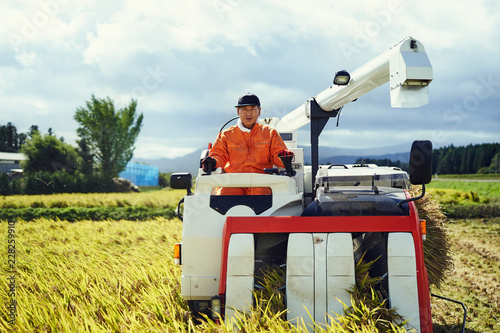 Man using combine harvester in field photo