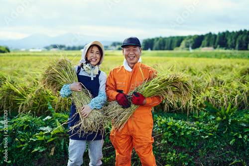 Mature farmers standing in field photo