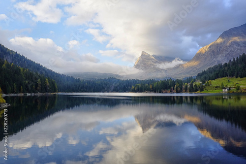St Bernard lake, Switzerland, Grigioni canton. Sunset light with clouds reflected in the water
