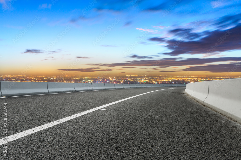 Fototapeta premium Modern city skyline and buildings with empty asphalt road at sunset