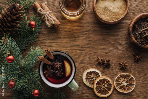 top view of spice mulled wine and fir twigs with baubles on wooden tabletop, christmas concept
