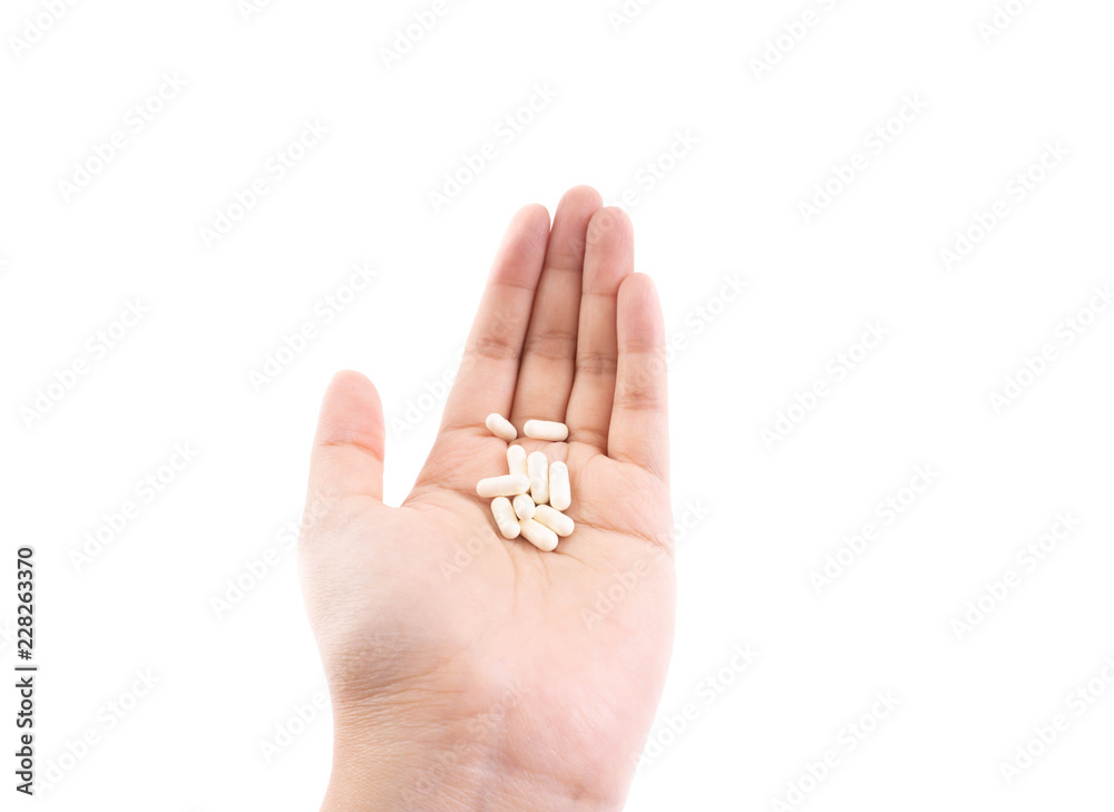 White capsules on palm of hand on isolated background. White capsules on palm of hand on isolated background.