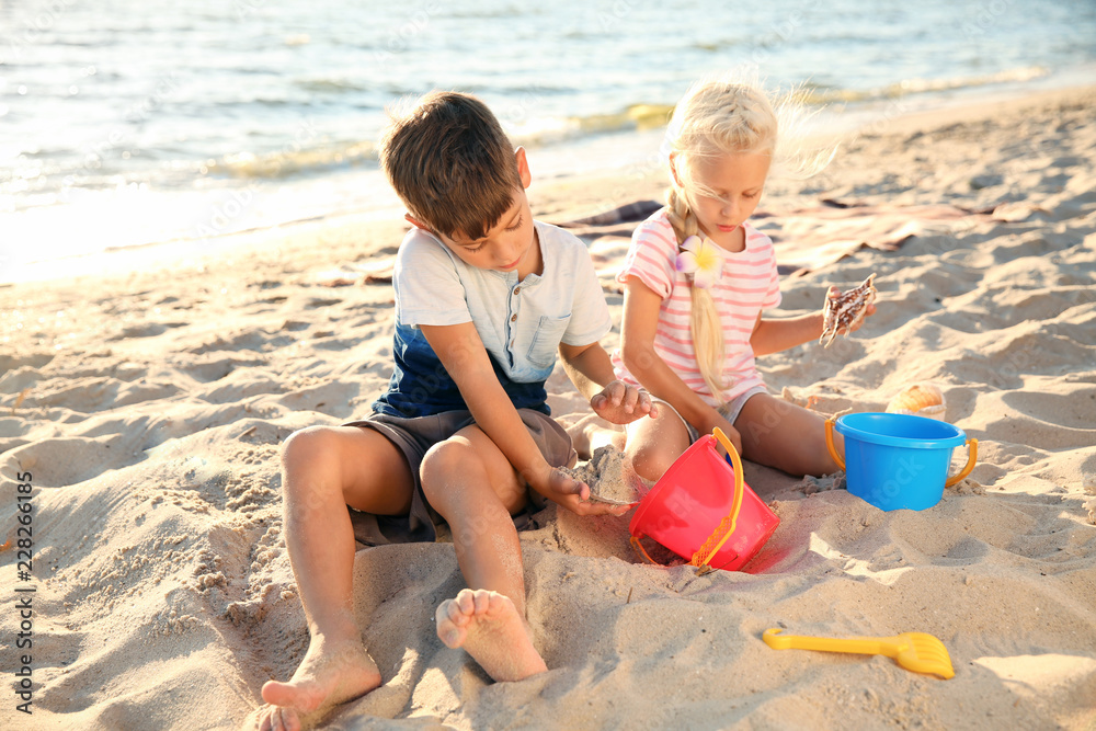 Cute little children playing with sand on sea beach Cute little children playing with sand on sea beach