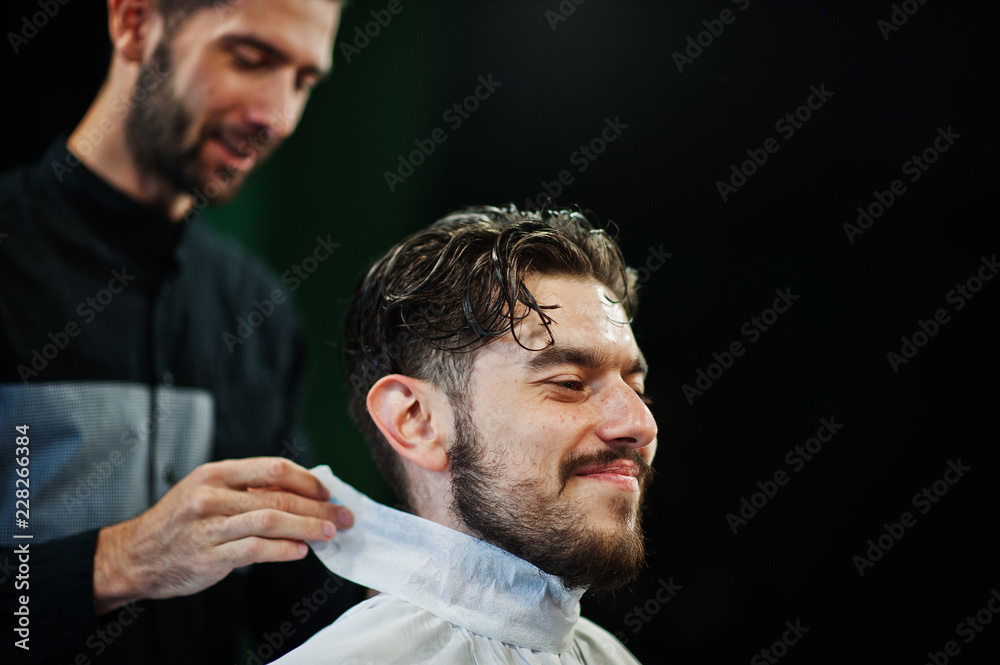 Fototapeta premium Handsome bearded man at the barbershop, barber at work.