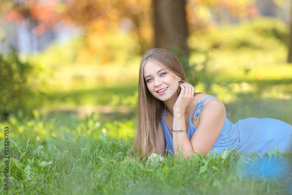 Beautiful young woman lying on green grass outdoors Beautiful young woman lying on green grass outdoors