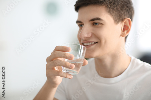 Young man drinking water at...