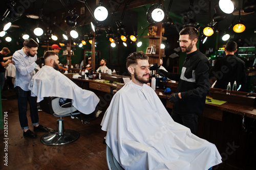 Handsome bearded man at the barbershop, barber at work.