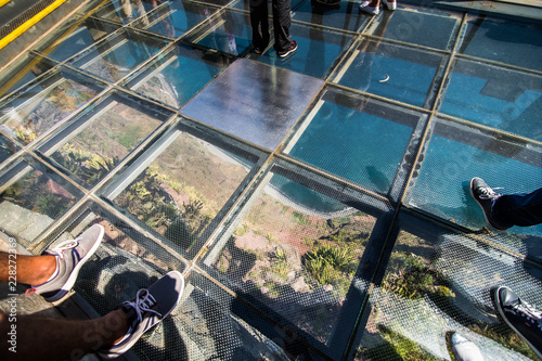 Madeira, Portugal - July, 2018: Skywalk at Cabo Girao, Madeira. View down to the atlantic ocean. The glass platform is 580 meters high. photo