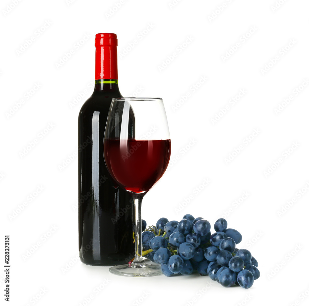 Bottle and glass of red wine with ripe grapes on white background