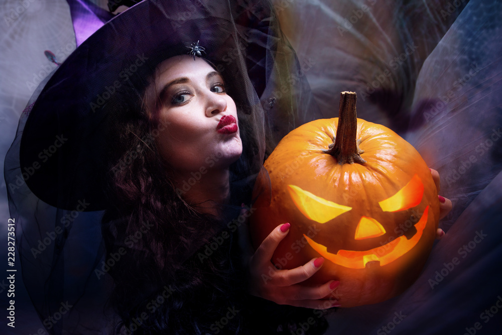 Halloween Witch with Pumpkin Beautiful young woman in witches hat and costume Halloween Witch with Pumpkin Beautiful young woman in witches hat and costume
