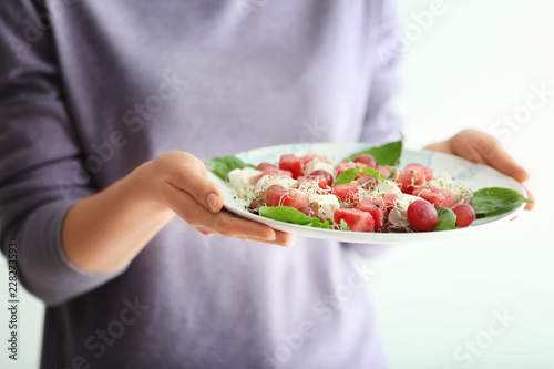 Woman holding plate with tasty watermelon salad  closeup