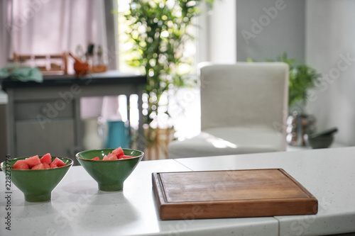 Cutting board and bowls with sliced watermelon on kitchen table © Pixel-Shot