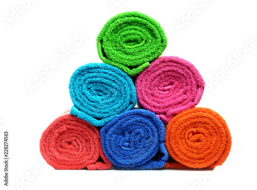 Stack of bright rolled towels on white background