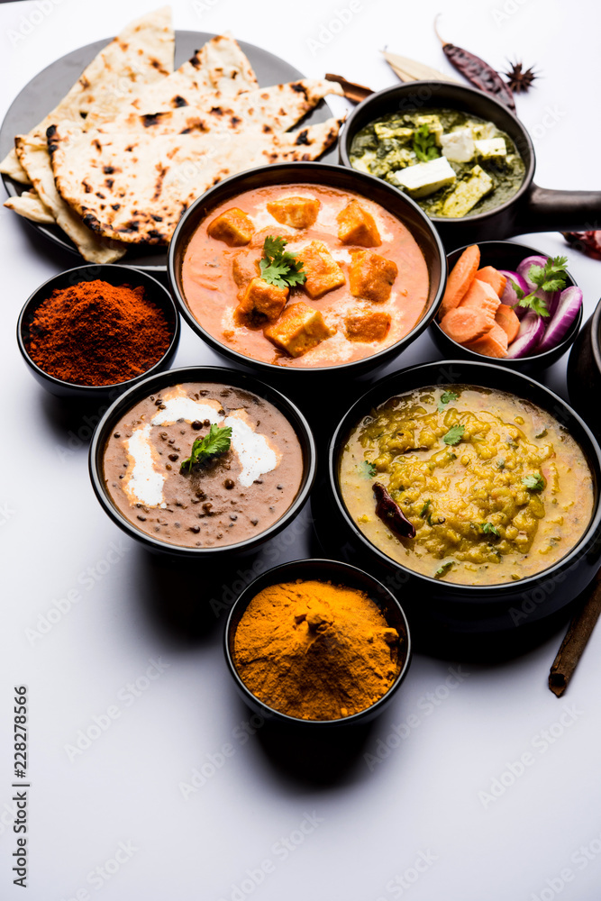 Indian Lunch / Dinner main course food in group includes Paneer Butter Masala, Dal Makhani, Palak Paneer, Roti, Rice etc, Selective focus