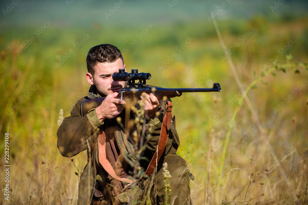 Fototapeta premium Guy hunting nature environment. Hunting weapon gun or rifle. Hunting target. Masculine hobby activity. Experience and practice lends success hunting. Man hunter aiming rifle nature background