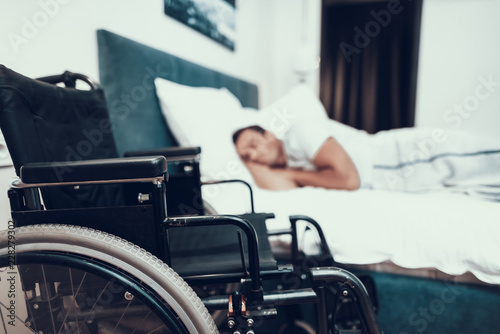 Disabled Person Sleeps Near Black Wheelchair