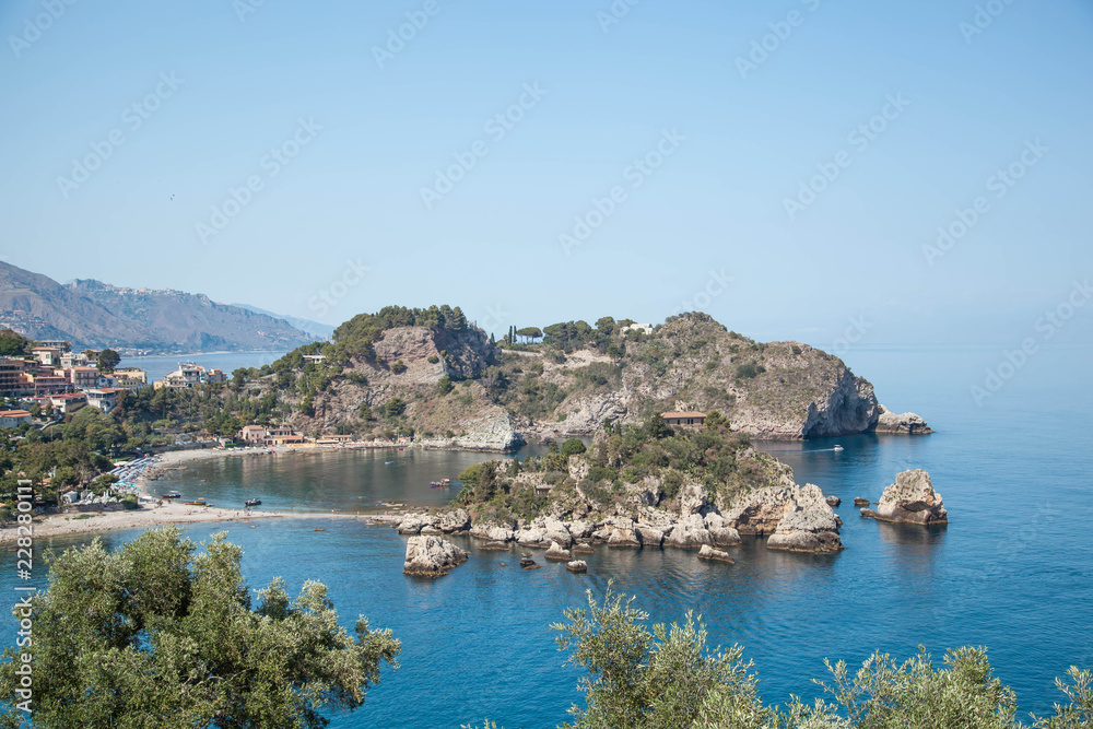 Panoramic view of Isola bella, Taormina, Sicily, Italy, blue sky and water with boats.