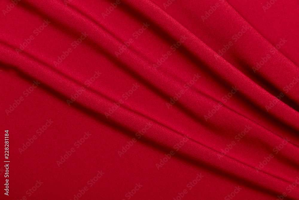 Background and texture. The concept of a hobby and production. Image of the texture of the fabric for sewing clothes. Red knitwear, wool. Abstraction. Cropped shot, isolated, close-up, blurred, horizo Background and texture. The concept of a hobby and production. Image of the texture of the fabric for sewing clothes. Red knitwear, wool. Abstraction. Cropped shot, isolated, close-up, blurred, horizo