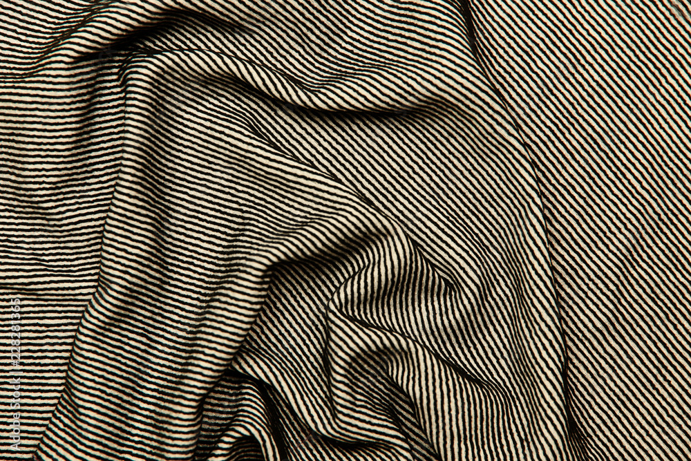 Background and texture. The blurred image of the texture of the fabric for sewing clothes. The combination of colors is black and white. Strip. Cropped shot, isolated, close-up, blurred, horizontal