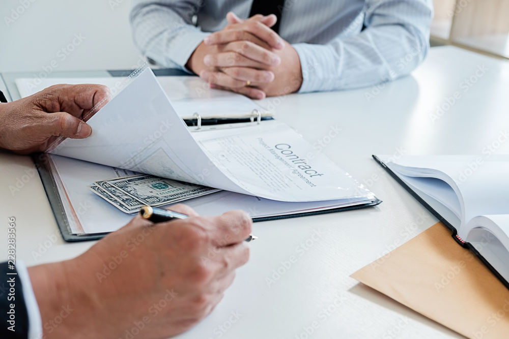 Businessman giving money while making deal to agreement a real estate contract and financial corporate.Bribery and corruption concept Businessman giving money while making deal to agreement a real estate contract and financial corporate.Bribery and corruption concept
