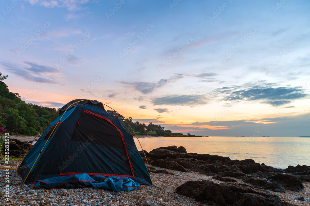 Dark blue tent on the beach with rock in the morning.