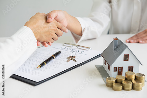 Real estate agent shaking hands with customer for deal contract to buy house, insurance or loan real estate