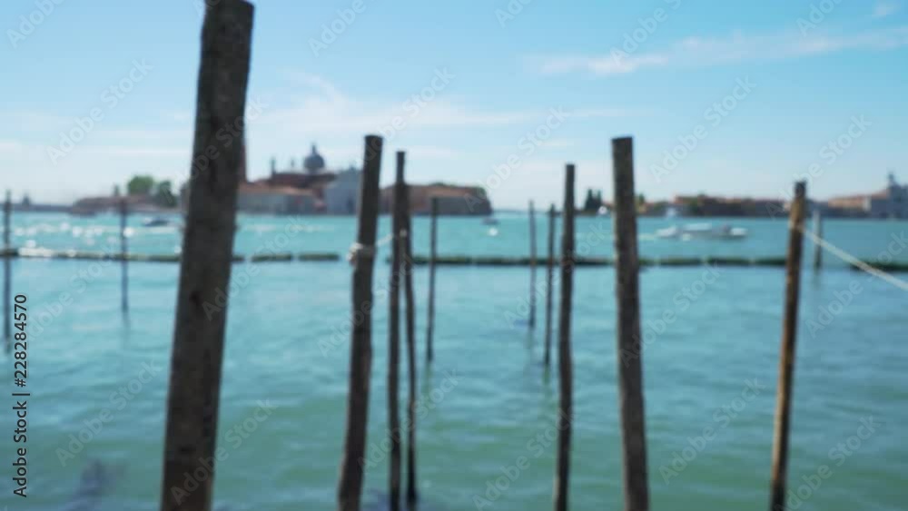 Blurred view of boat dock in Venice Italy under blue sky in summer Close up of wooden poles for Venetian gondolas in the Grand Canal 4k Blurred view of boat dock in Venice Italy under blue sky in summer Close up of wooden poles for Venetian gondolas in the Grand Canal 4k