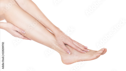 to apply foot cream it is removed in studio isolate on a white background. © Stavros