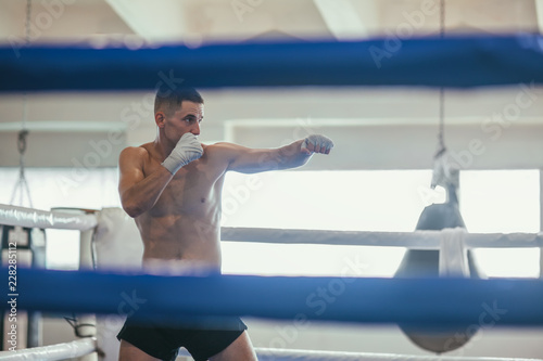 Male boxer during boxing exercise making direct hit