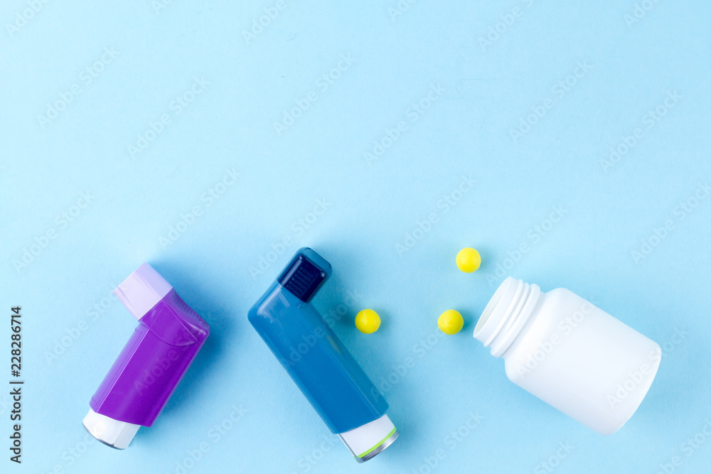 Asthma inhalers and pills on a blue background. Copy space Asthma inhalers and pills on a blue background. Copy space