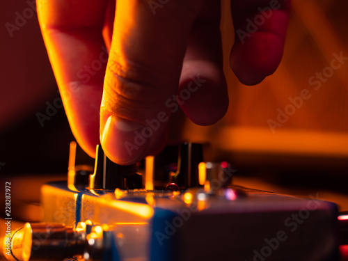 Photography Musician tuning guitar effect pedal for best music during concert on stage