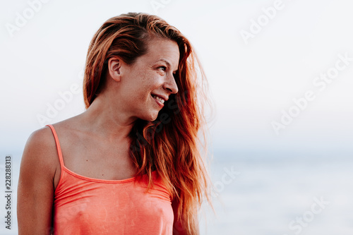 Young woman by the sea at sunset