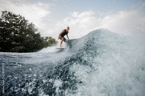 Wakesurfer on the background and blue splashing water on foreground