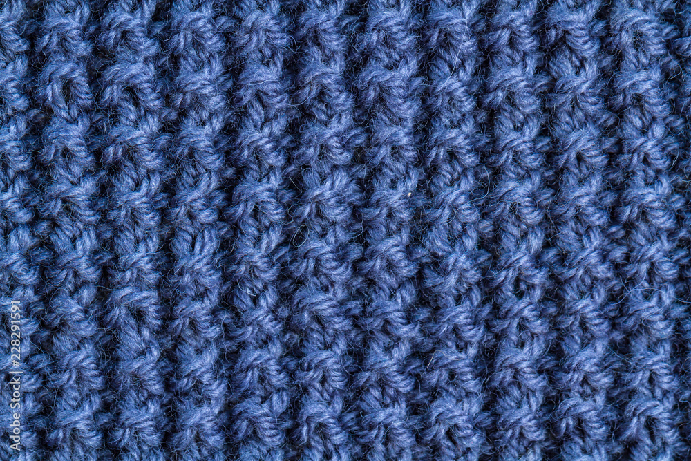 The texture of a blue knitted yarn. Knitted and winter clothes