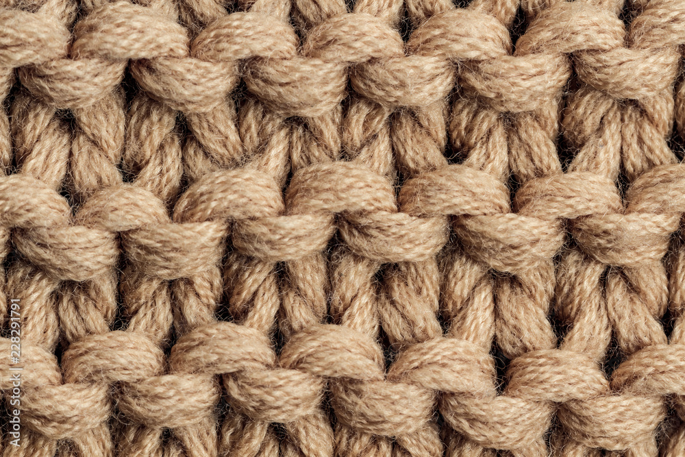 The texture of a brown knitted yarn. Knitted and winter clothes