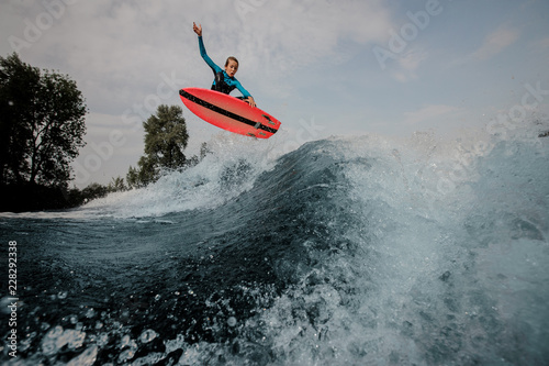Quadro em tela Emotional teenager boy jumping on the orange wakeboard