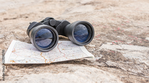 the binoculars on the old map orienteering Hiking direction stone background photo