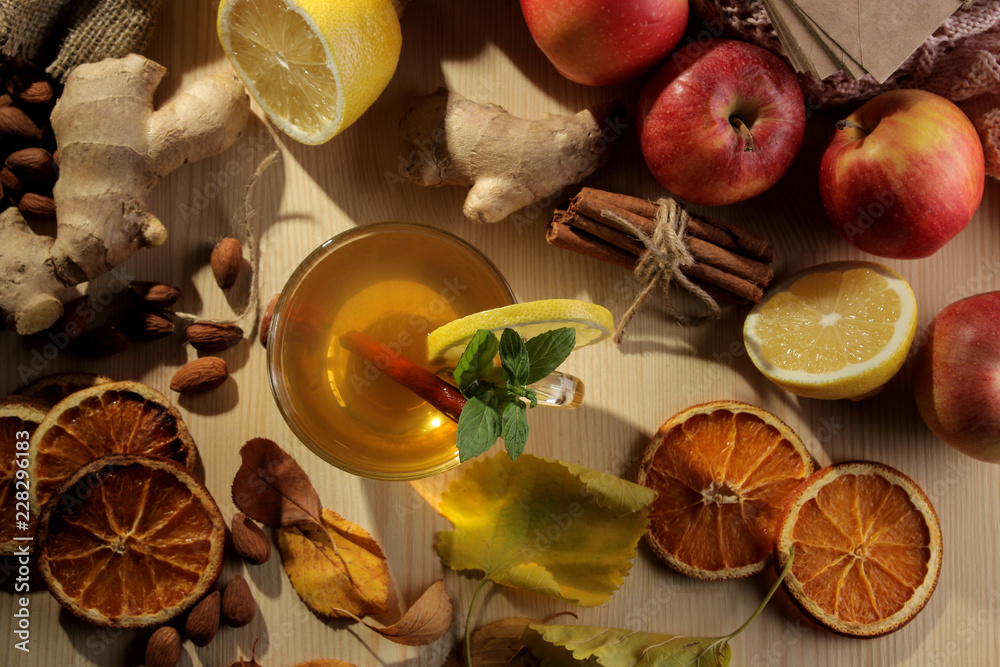 Autumn composition with hot tea, fruits and yellow leaves on a natural wooden table. view from above Autumn composition with hot tea, fruits and yellow leaves on a natural wooden table. view from above